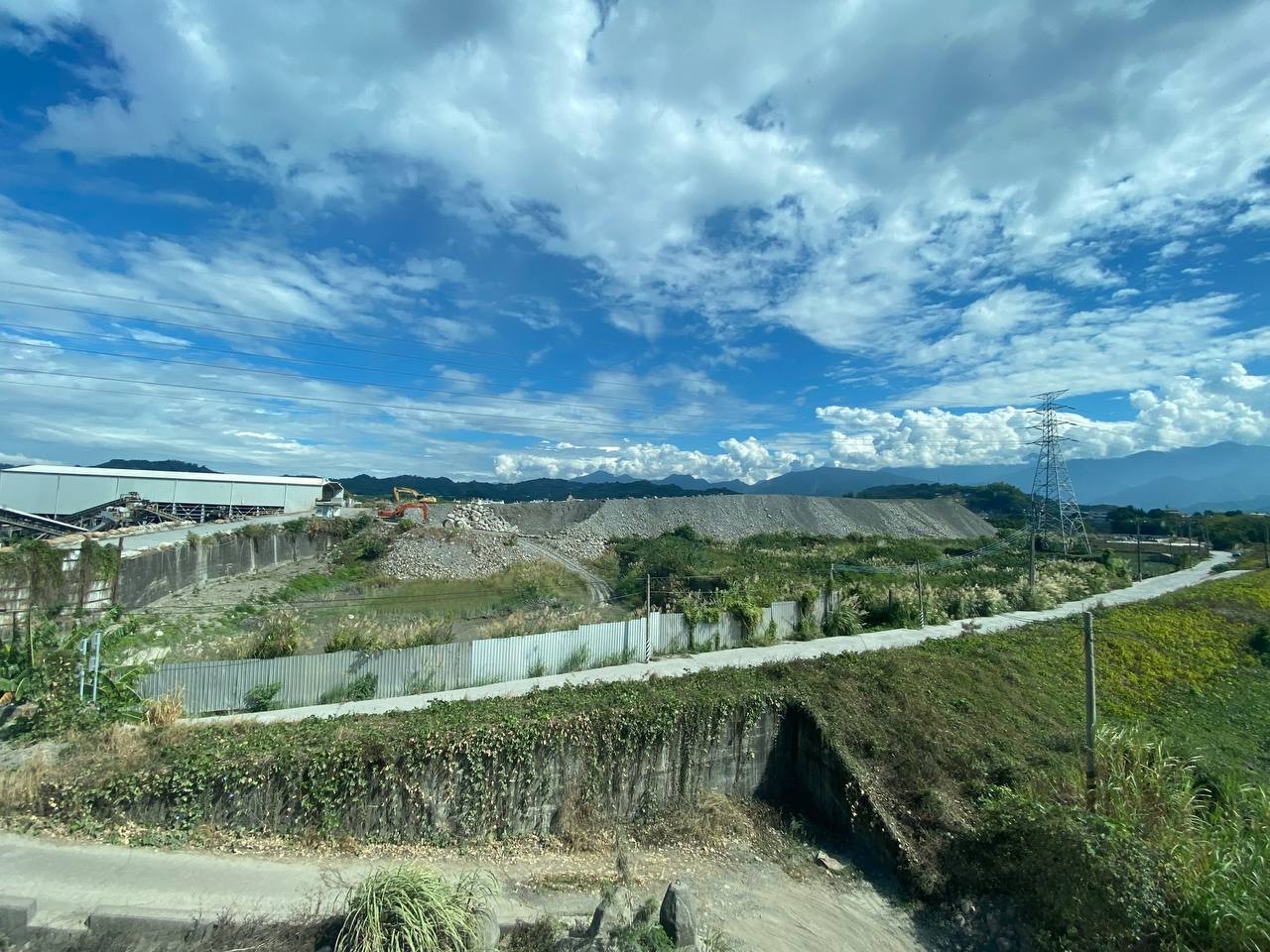 肉眼已可見違反堆積的砂石快比一旁高壓電塔高。翻攝洪申翰臉書