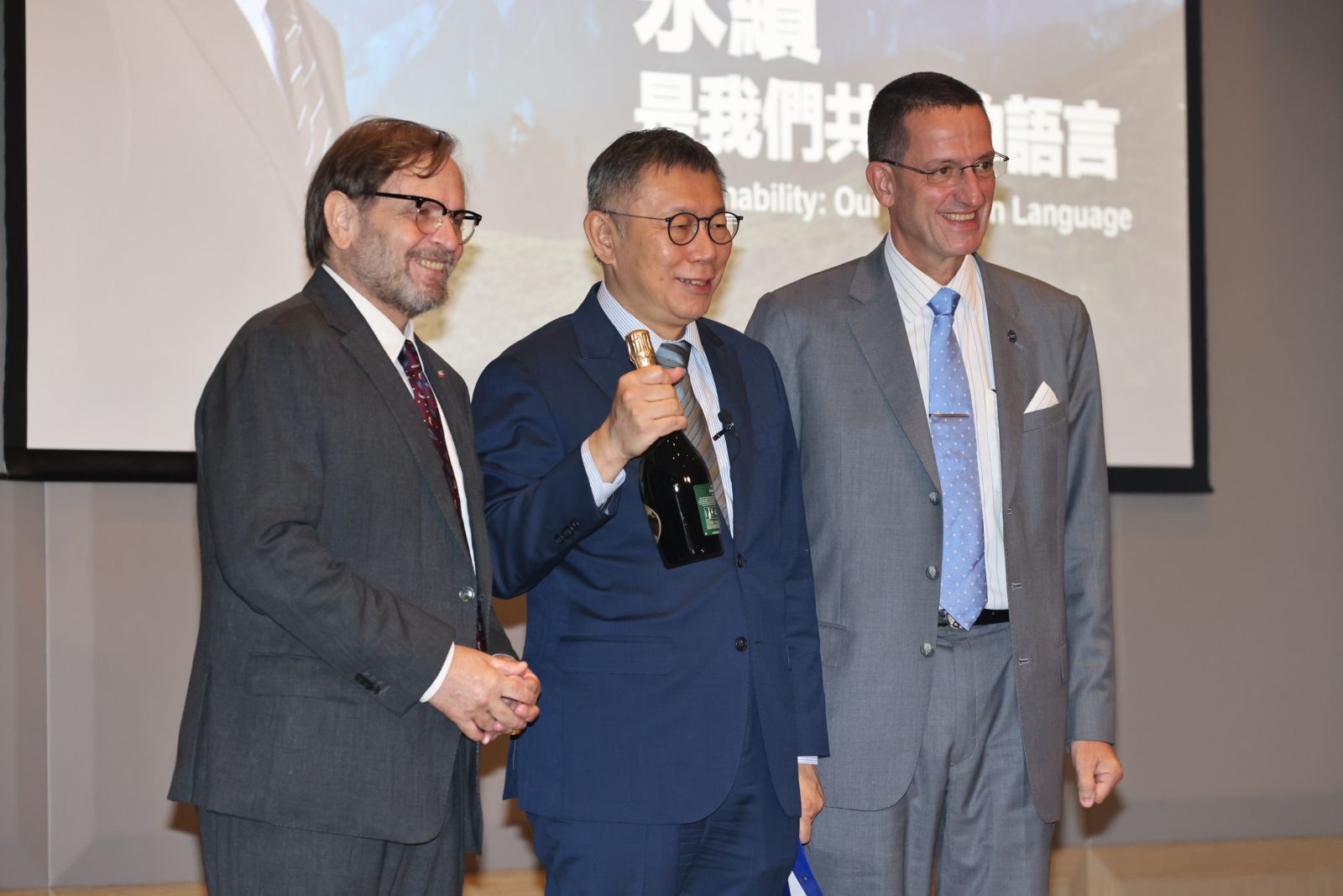 歐洲在台商會理事長尹容(Giuseppe Izzo)(左)、執行長何飛逸(Freddie Hoglund)(右)送給柯文哲1瓶香檳,預祝他高票當選。林啟弘攝