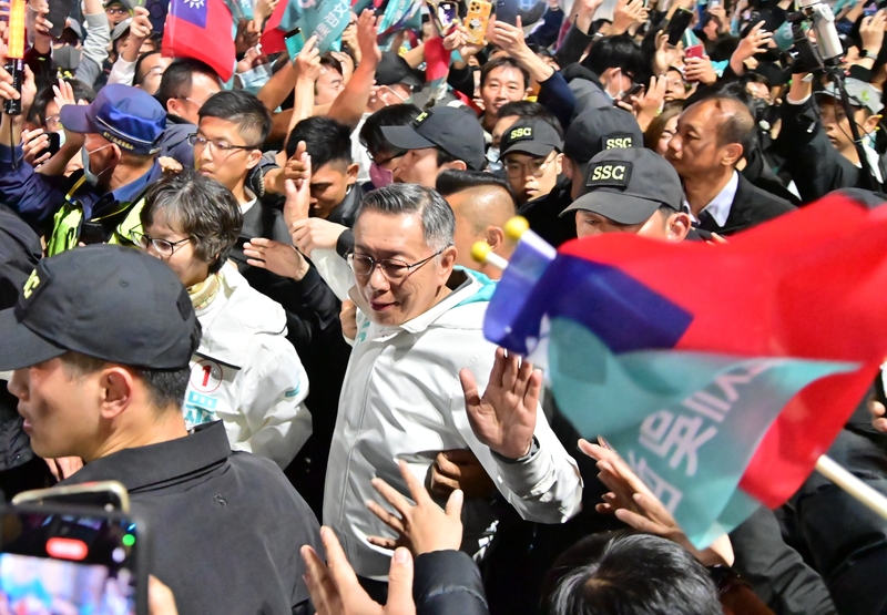 民眾黨6日選前黃金週六選在台中市大里區舉辦造勢晚會,黨籍總統候選人柯文哲(中白衣者)進場受歡迎,沿路他也伸出手和支持者們擊掌互動。 中央社