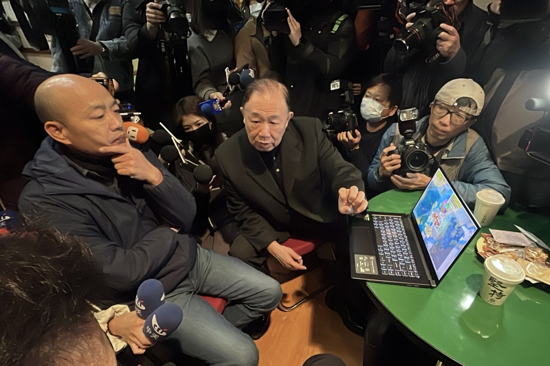 國民黨不分區立委當選人陳永康(中)與韓國瑜(左)分享國際地緣政治。中央社