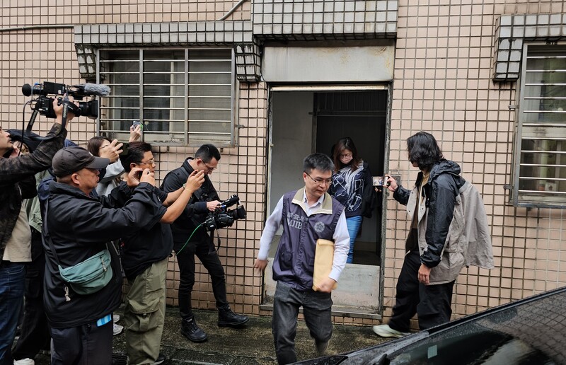 新北地檢署28日偵辦罷免涉不實連署案,指揮搜索國民黨新北市黨部,帶走書記長陳貞容(後,著牛仔褲者)、朱姓書記及三重區黨部執行長羅大宇。中央社
