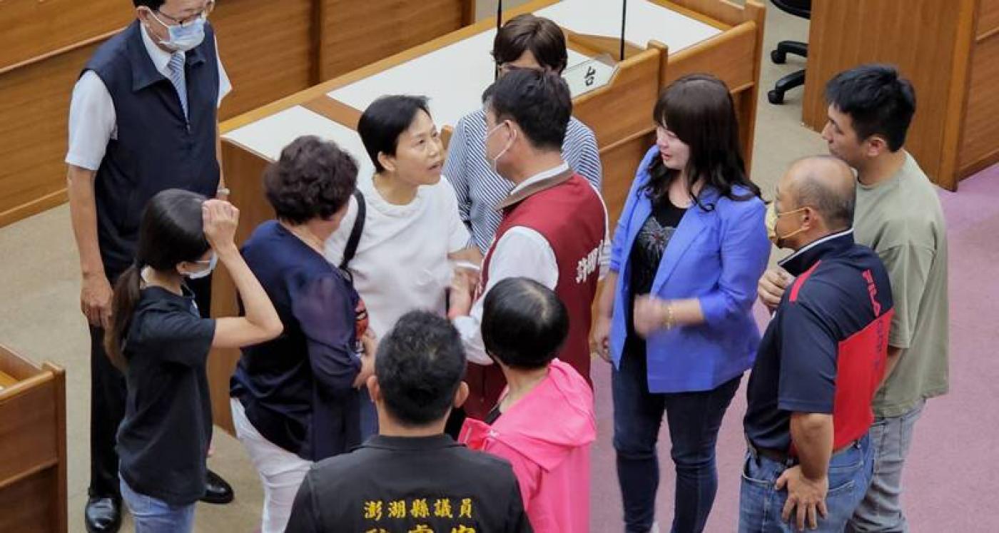 澎湖縣議會7日召開臨時會，議長劉陳昭玲（圖中白衣者）於會中宣布請辭，在她走下主席台後，與會議員給予安慰、擁抱。 中央社