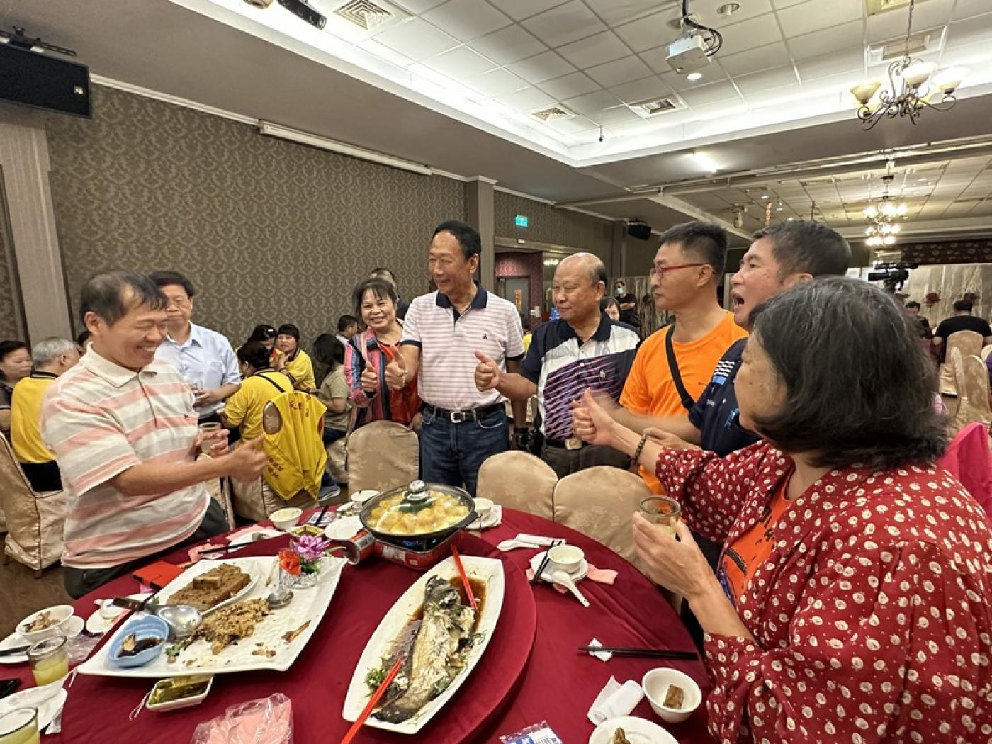 鴻海集團創辦人郭台銘（前右5）15日南下台中出席 里長聯誼晚宴，餐敘時和與會者一齊比讚，現場氣氛 熱絡。