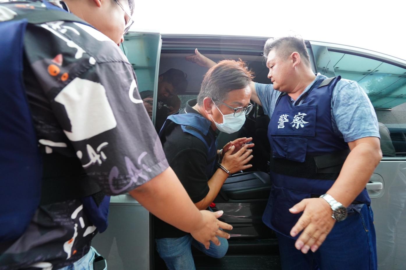 警方將宜蘭縣政府公共造產前專員許智信(中，銬手銬者)押解至地檢複訊畫面。資料照片／林泊志攝