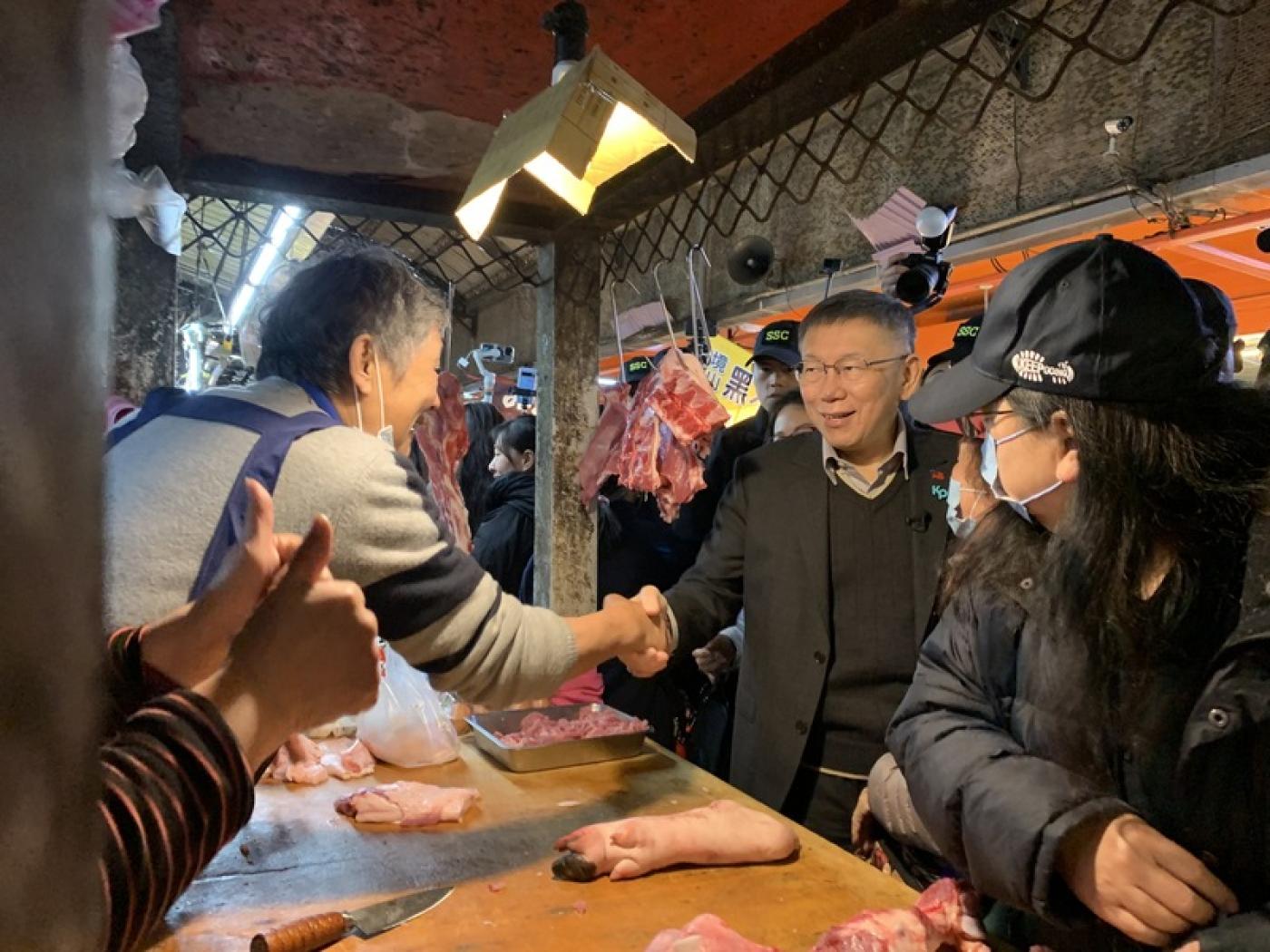 柯文哲23日上午到桃園平鎮山仔頂市場掃街，支持者熱情拍照合影、握手。中央社