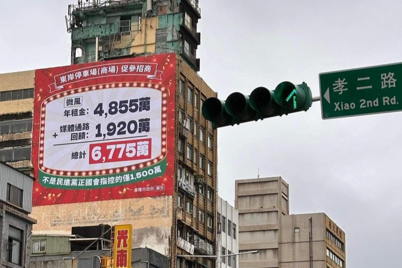 基隆市政府24日在忠一路大樓外牆高掛起巨幅紅底廣告，內容提到「東岸停車場（商場）促參招商」收入數據，挨批公器私用。翻攝張之豪臉書