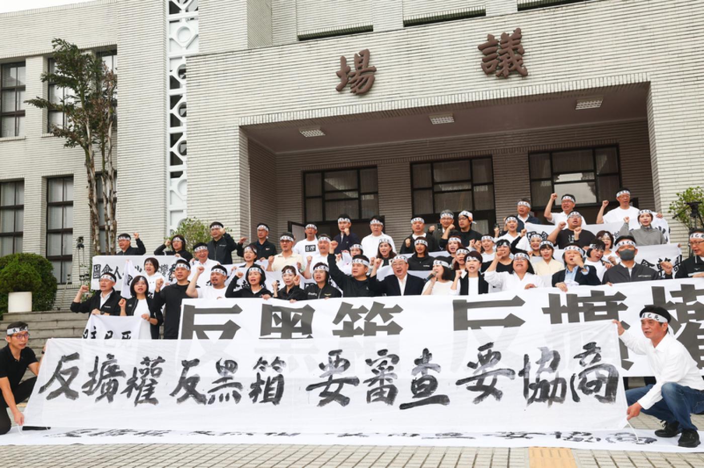 民進黨團在議場前拉起「反擴權 反黑箱 要審查 要協商」布條，抗議國民黨與民眾黨團破壞民主審查程序。中央社