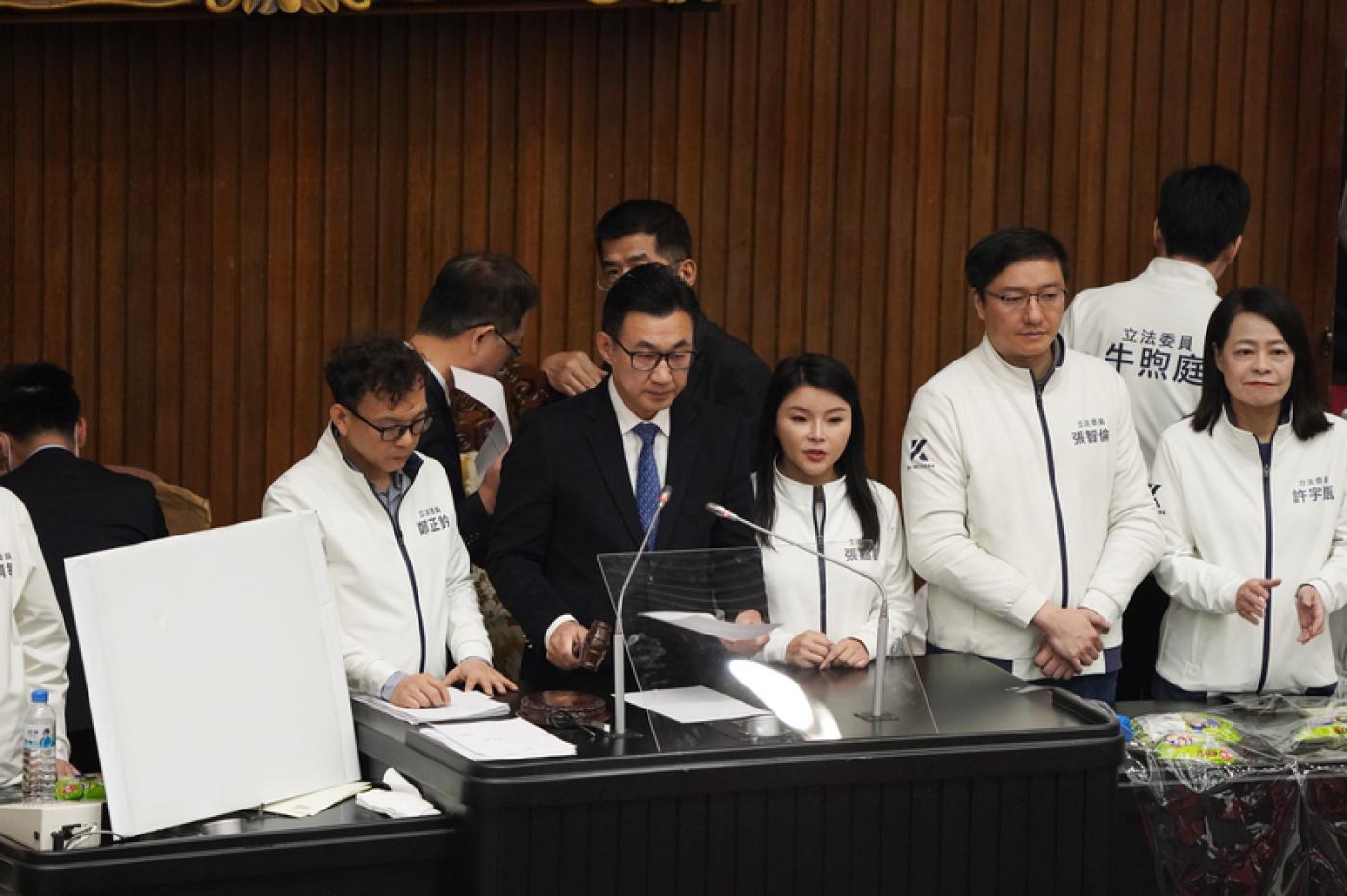立法院會20日在衝突中以舉手表決三讀修正通過選罷法部分條文，立法院副院長江啟臣（前左2）在多名國民黨籍立委包圍陪伴下，正式敲槌宣布選罷法三讀。中央社