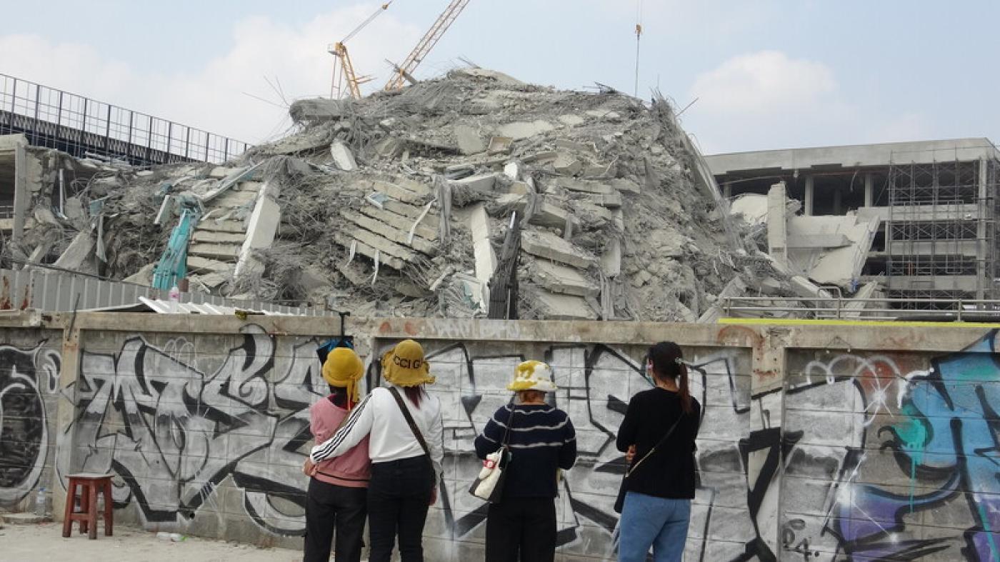 曼谷興建中的大樓受強震波及倒塌。受困工人的親友站在工地外望著倒塌建築物。中央社