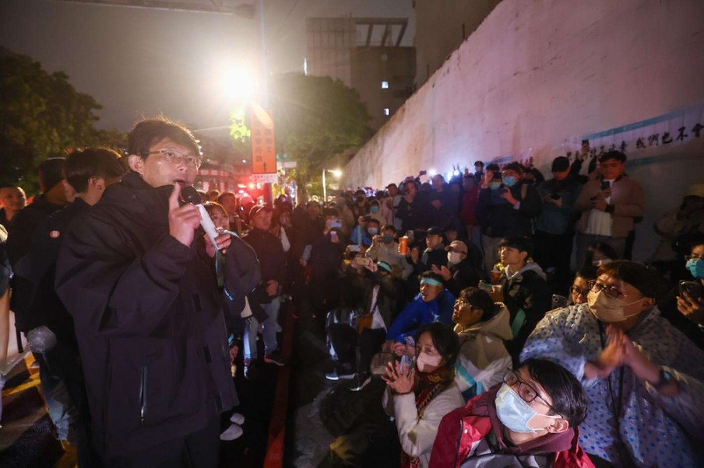 台灣民眾黨主席黃國昌（前左）29日傍晚起在台北看守所外靜坐，現場陸續聚集不少支持者。晚間近10時，柯文哲身體不適安排戒護外醫，消息傳出，黃國昌也向群眾喊話，希望大家早點回家休息。 中央社