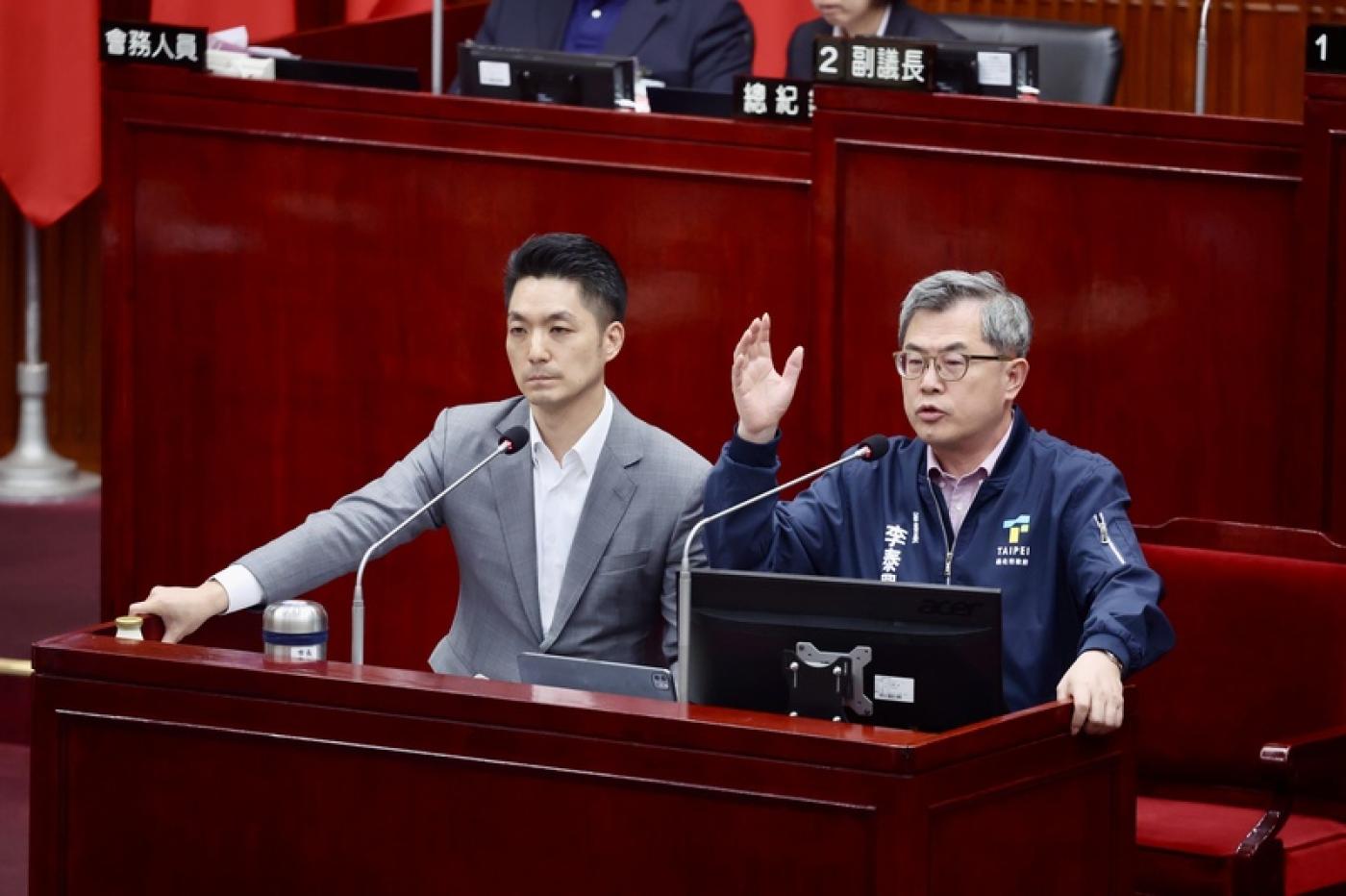 台北市長蔣萬安（左）與秘書長兼北市選委會主委李泰興（右）3日在議會備詢，質疑中選會外洩公文。中央社