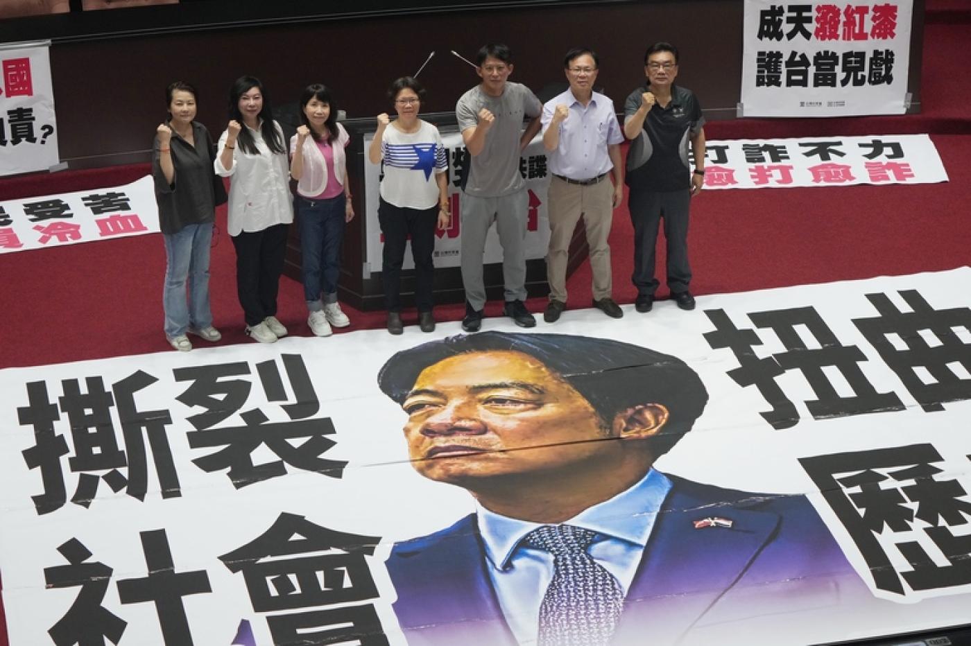 民眾黨團徹夜排隊為搶先遞案，4日一早民眾黨立委進入議場後將標語貼在議場中央並合影。中央社