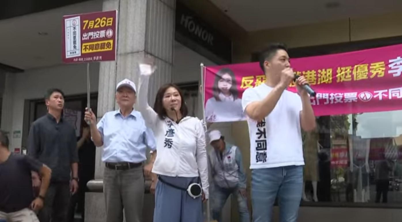 蔣萬安身穿自製的「我不同意」T恤陪同李彥秀在街頭拜票。翻攝畫面